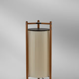 Kando P/111 Ribbon LED floor lamp with a pleated white cylindrical shade inside a wooden three-legged frame topped with a dark disc, shown against a plain grey background.