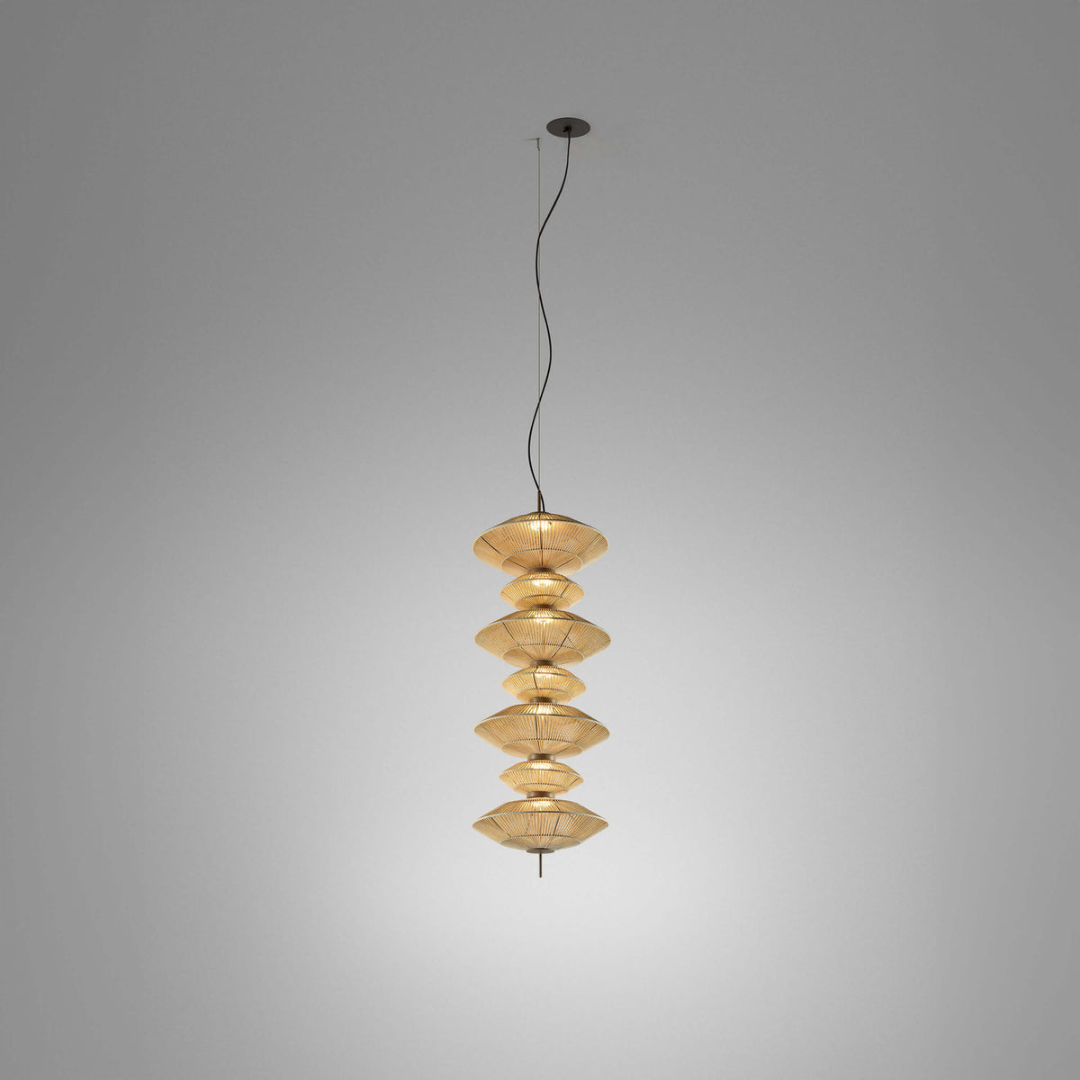 Yuyun S/7C fabric LED pendant light with seven stacked round woven tiers in satin beige, suspended from a single cable on a plain grey background.
