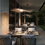 Mediterrània S/105 outdoor pendant light with wide disc-shaped brown fibre shade and white ribbed diffuser, shown above an outdoor dining table on a covered patio.