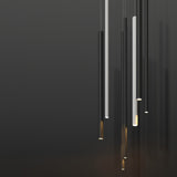 Slender matt black aluminium linear LED pendant lights of varying lengths with warm white glow, shown alongside white tube pendants against a dark background.