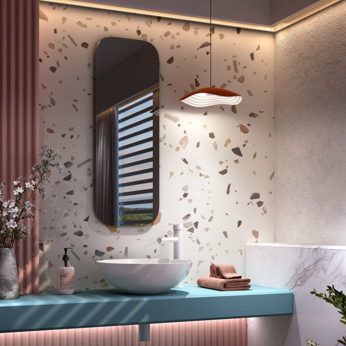 Valentina S/24 LED pendant light with wavy terracotta and white aluminium shade, hung above a bathroom vanity against a terrazzo-patterned wall.