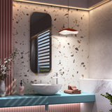 Valentina S/24 LED pendant light with wavy terracotta and white aluminium shade, hung above a bathroom vanity against a terrazzo-patterned wall.
