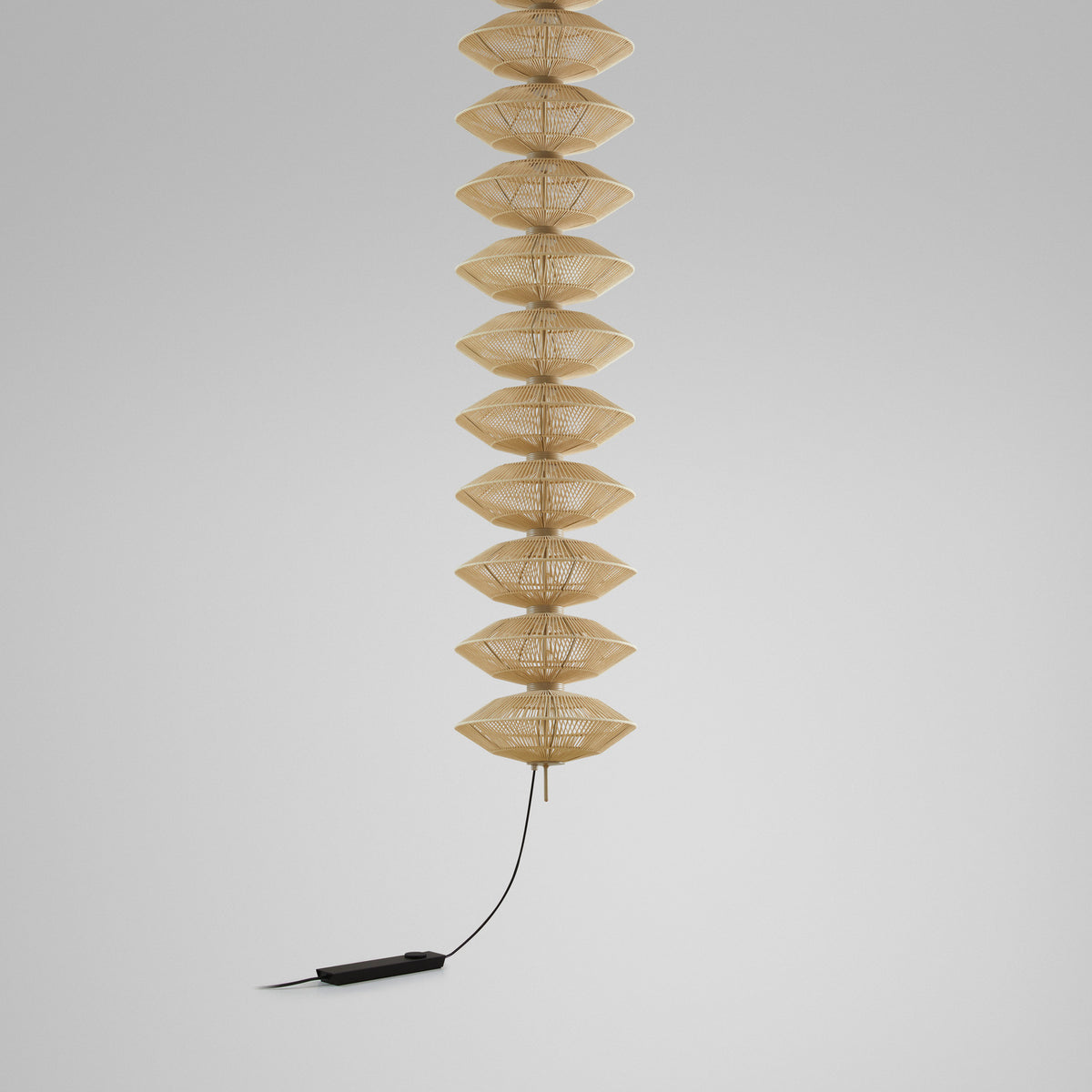 Yuyun S/11L/I pendant light with eleven stacked double-cone beige thread shades on a slim stem, satin beige finish, foot dimmer cord, shown against a plain light grey background.