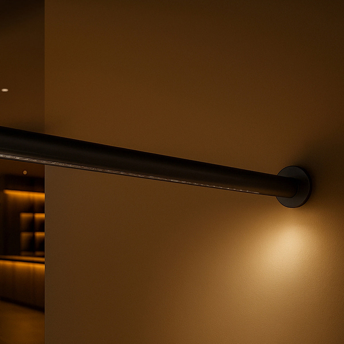 Solid WS 160 Tube LED wall light in matte black, showing the slim round tube and circular wall plate casting warm ambient light in a dimly lit interior.