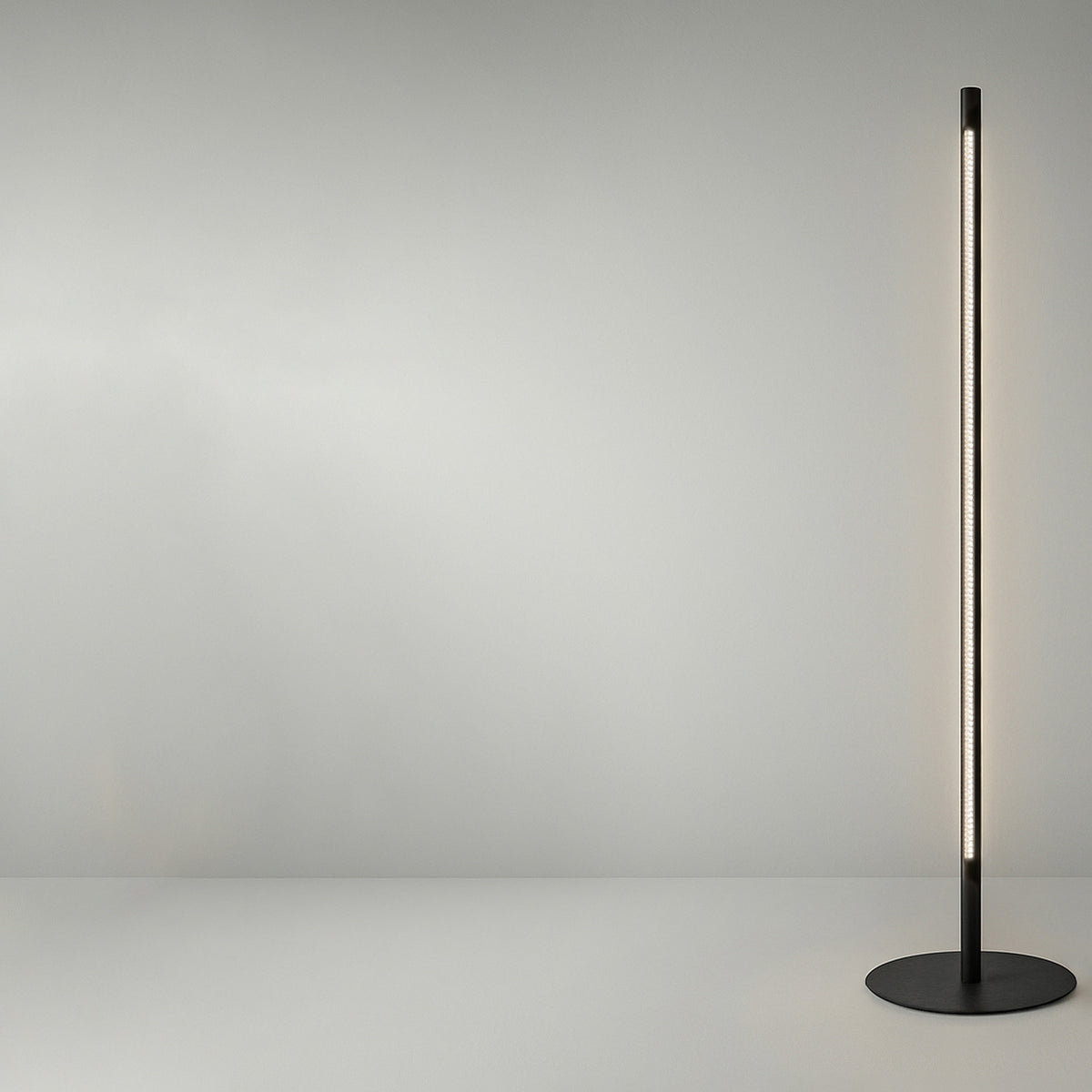 Solid F 180 Cylinder LED Floor Lamp with a slim black column on a round flat base, illuminated along a vertical strip against a plain light grey background.
