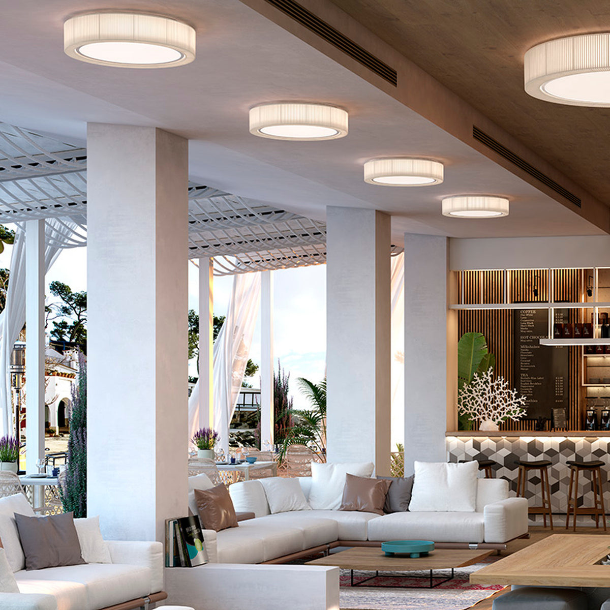 Urban PF/90 Ribbon LED Ceiling Lights in white, round drum design with pleated ribbon texture, installed in a row along a sloped ceiling above a lounge seating area.