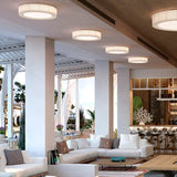 Urban PF/90 Ribbon LED Ceiling Lights in white, round drum design with pleated ribbon texture, installed in a row along a sloped ceiling above a lounge seating area.