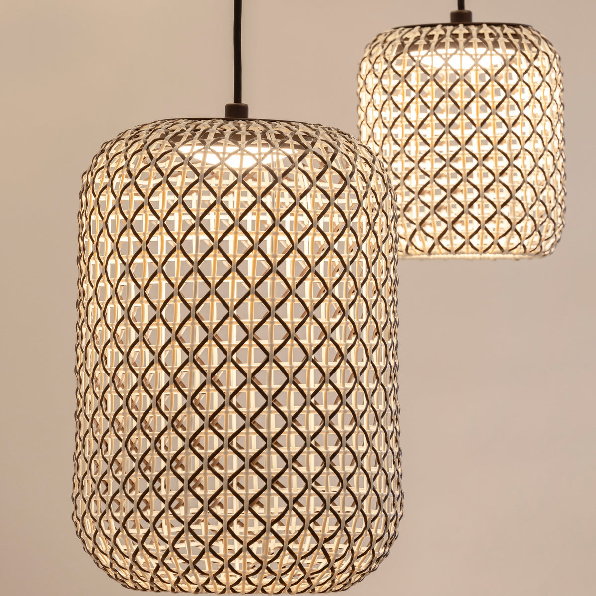 Nans S/31.2 woven outdoor pendant lights with lit brown lattice shades in a rounded barrel shape, shown in pairs against a neutral background.