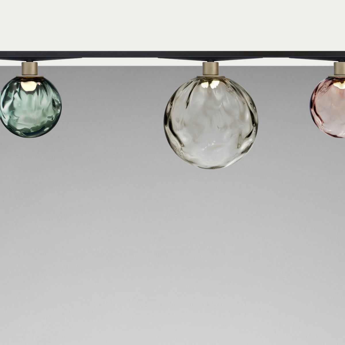 Murané Street track ceiling light with rippled transparent glass globes, 10cm, in green, clear, and pink, on brushed champagne collars beneath a black track.