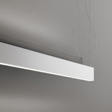 Giano Aluminium Linear LED Pendant Light, a slim white rectangular bar suspended on fine wires with a narrow underside diffuser, shown against a plain grey background.