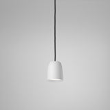 Nut S/10 pendant light with a small bell-shaped white textured shade, stainless steel and aluminium construction, black cord, shown on a plain grey background.