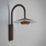 Fanalet A/02 aluminium outdoor wall light with tall arched arm, flat wide shade in graphite brown with white underside, integrated LED, shown on a plain grey background.