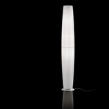 Maxi P/03 Ribbon Cylinder Floor Lamp with a tall, tapered white pleated ribbon shade on a round base, set against a plain black background.