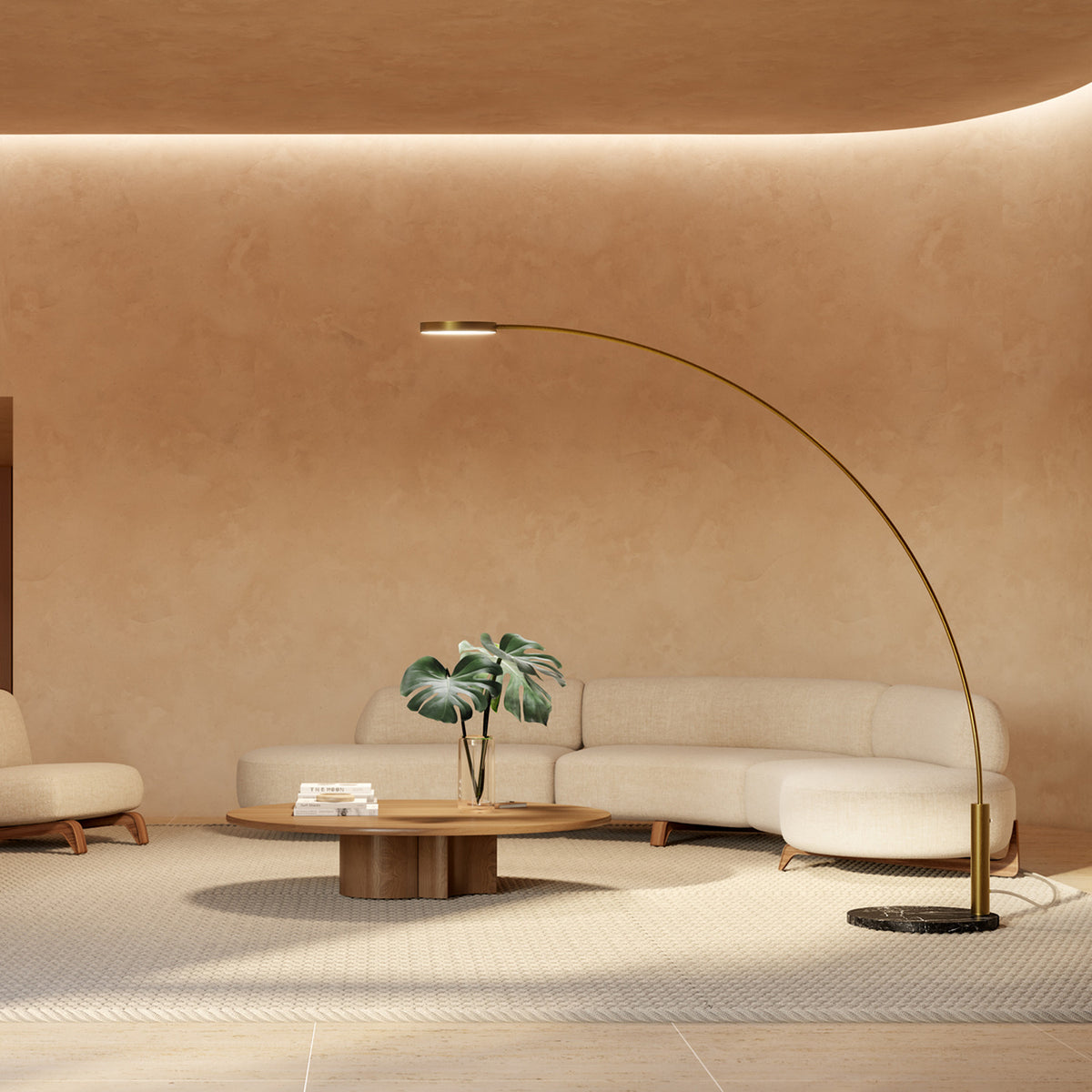 Dip Nero Marquina arc LED floor lamp with brushed brass curved arm, flat disc head and black marble round base, shown beside a beige sofa in a living room.