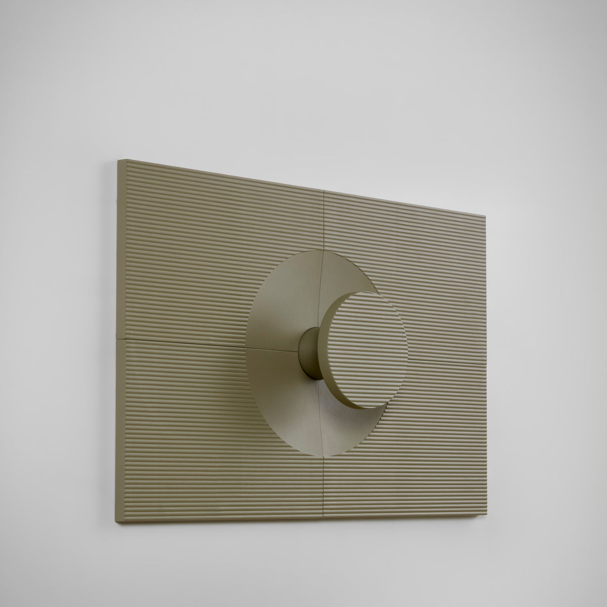 Arid Wall Light Tile in Textured Olive Grey, a fluted aluminium panel with a central circular cut-out and cylindrical light detail, shown at an angle against a plain white background.