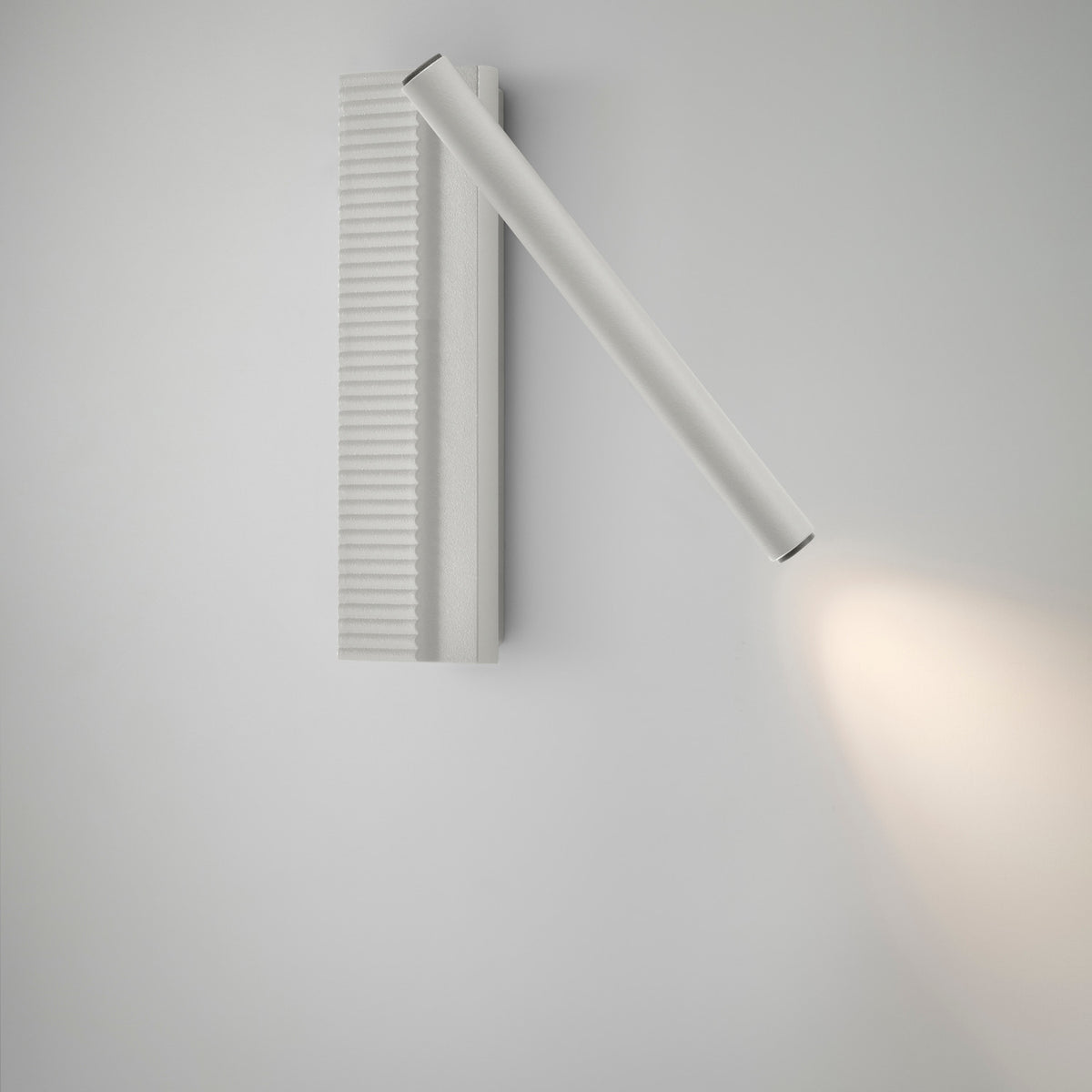 Arid A/03 aluminium LED wall light in Textured White, with a ribbed vertical back plate and an angled slim tube casting warm light, shown on a plain white background.
