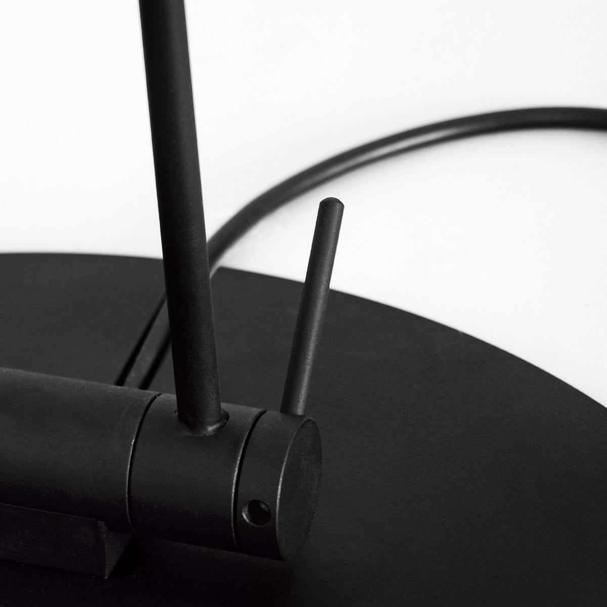 Speers F 2 Light LED Floor Lamp, close-up of matte black stems and round disc base with integrated LED heads, against a plain white background.