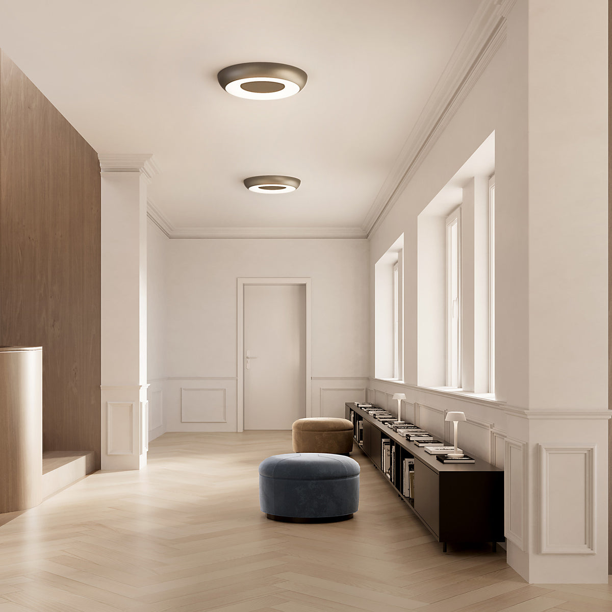 Two round Superbold LED ceiling lights, 44.3cm, in bronze finish with glowing white ring, installed in a neutral hallway above a dark sideboard and windows.