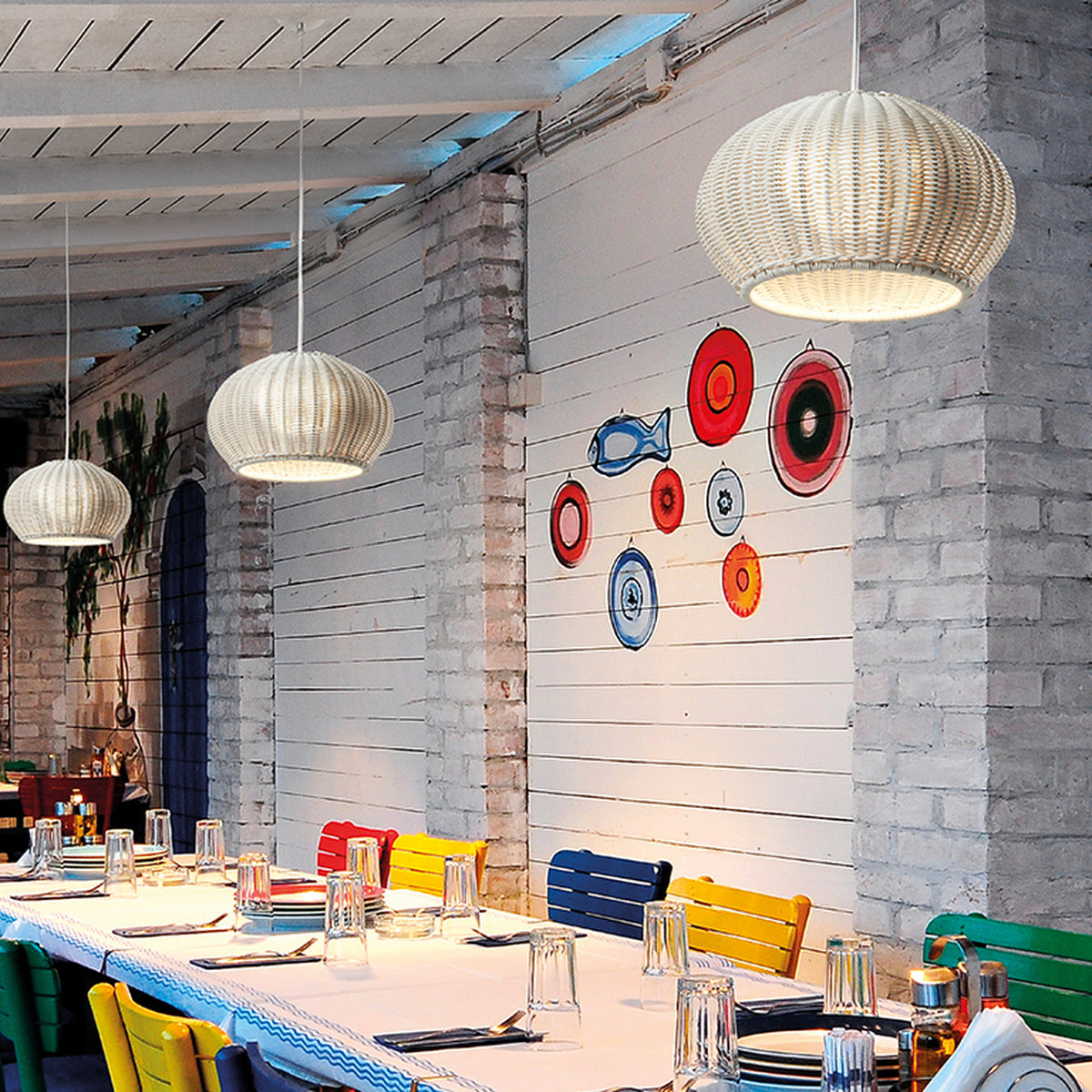 Garota S/01 Globe LED Outdoor Pendant Light in Ivory White, ribbed round shade, shown in multiples above a dining table on a covered patio.