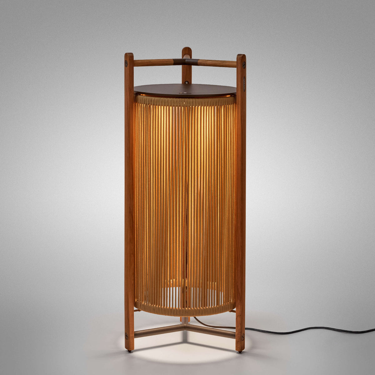 Kando P/111 outdoor floor lamp, lantern-style with teak wood frame and sand nautical cord cylinder, dark brown top disc, integrated LED glow, on a plain light background.