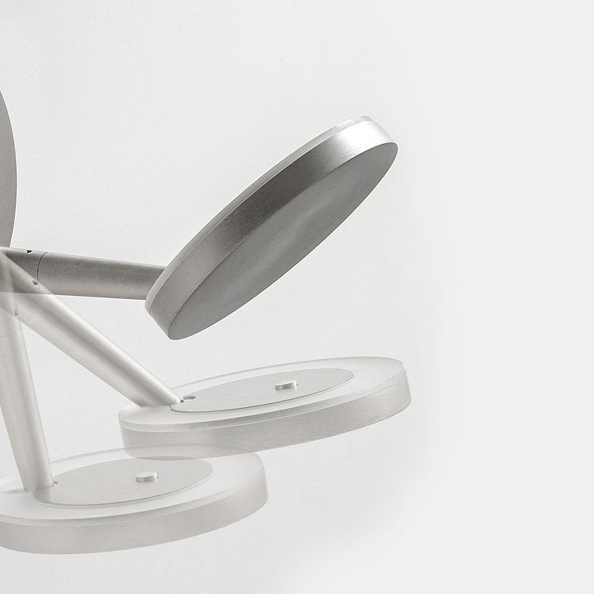 Bella Direct Aluminium LED Wall & Ceiling Light close-up, showing round brushed silver base, slim angled arm and tilted flat disc head, on a plain white background.