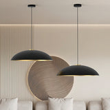 Rebeca Dome Pendant Light in matt black and gold, shown as two wide, shallow aluminium domes with gold undersides hung at different heights in a living room setting.