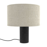 Romy Drum Table Lamp with a wide beige cotton drum shade on a cylindrical black marble base with pale veining, shown on a plain white background.