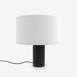 Romy Drum Table Lamp with a cylindrical black marble base showing pale veining and a white cotton drum shade, shown on a plain white background.