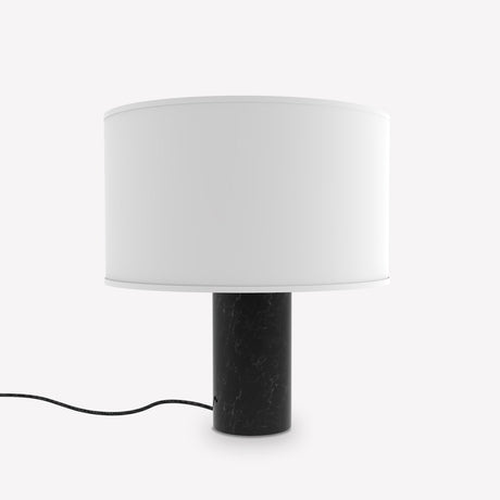 Romy Drum Table Lamp with a cylindrical black marble base showing pale veining and a white cotton drum shade, shown on a plain white background.