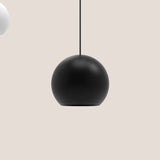 Nelly Globe Pendant Light in matt black aluminium, spherical shade on a black textile cable, shown against a plain light background.