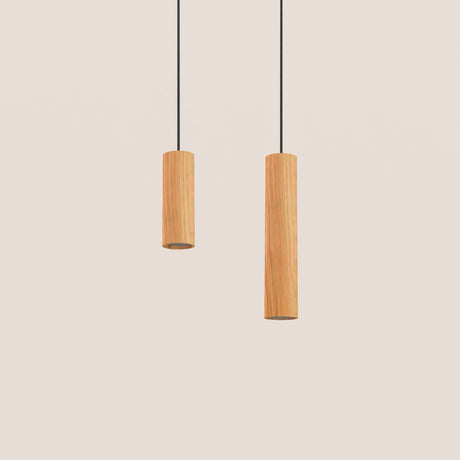 Taria Cylinder Pendant Light in Ash shown in two heights, slim wood cylinder shades on black textile cables against a plain light background.