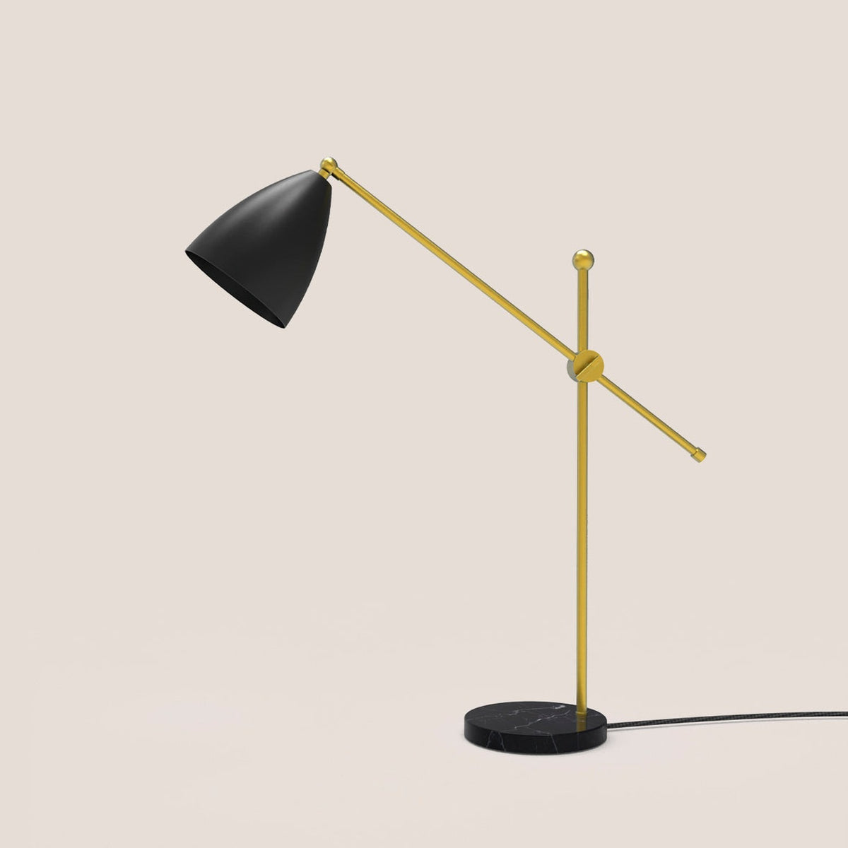 Nala Dome Adjustable Table Lamp with matt black dome shade on a long gold counterbalanced arm, pivoting on a slim gold upright with round black marble base, shown on a plain light background.