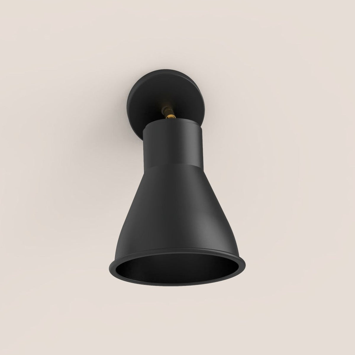 Cira Cone Wall Light in matt black with a slim gold stem and round wall plate, featuring a conical aluminium shade, shown on a plain light background.