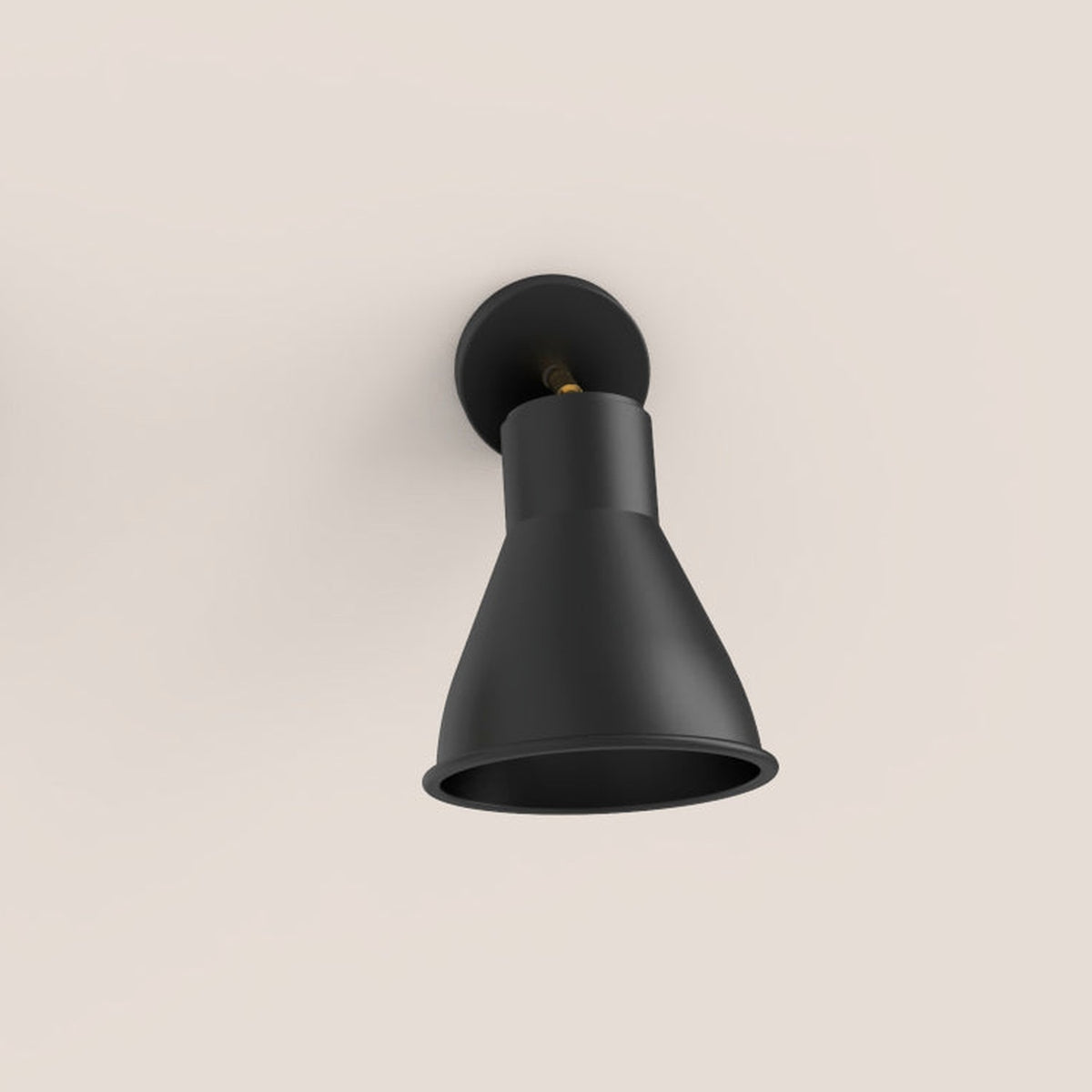 Cira Cone Wall Light in matt black with a gold stem and round wall plate, conical aluminium shade angled downward on a plain light background.