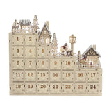 Richie Wooden Advent Calendar with Light in natural plywood, featuring 24 numbered drawers beneath a tiered winter village scene with houses, fir trees and deer.