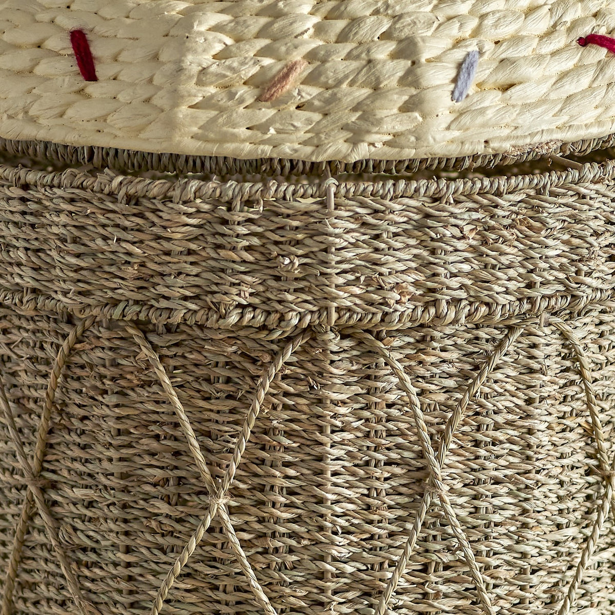 Close-up of the Cillie Seagrass Basket with Lid 72cm, showing the natural woven seagrass body with crisscross cord detail beneath a cream stitched lid edge dotted with coloured thread accents.
