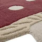 Close-up of the Mushroom Wool Rug 90x85cm in red, showing tufted red pile with cream spots meeting a textured cream stalk section with ridged detailing.