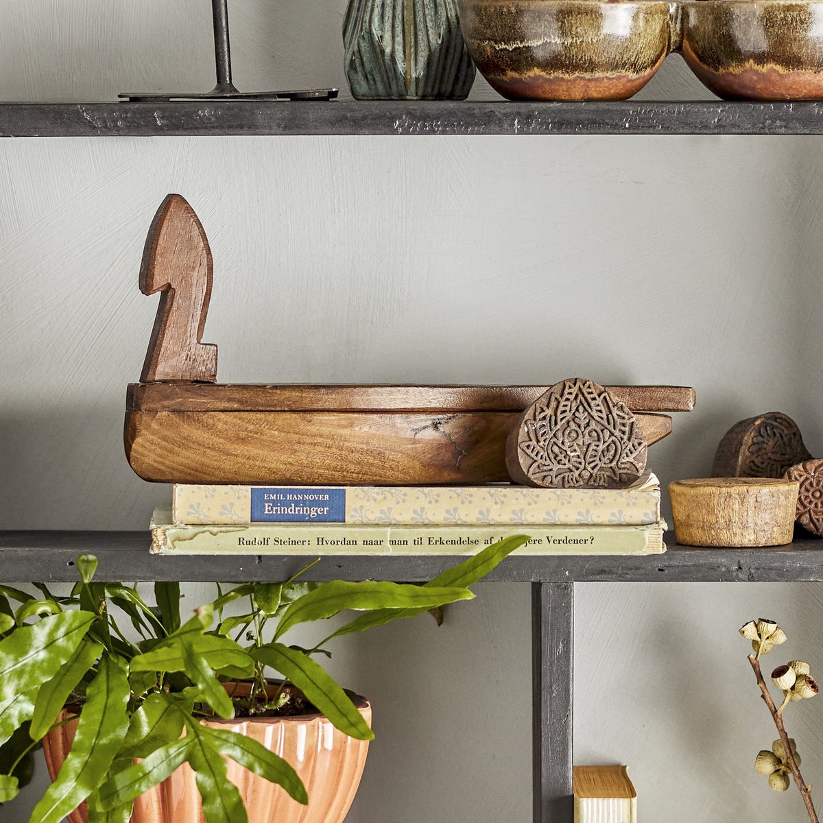 Hamida fish-shaped wooden storage box with lid in brown reclaimed wood, chevron-carved scales and notched tail, shown open on a shelf beside books and decor.