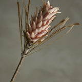 Palmflower Artificial Stem in pink, showing a cone-shaped flowerhead with layered petals and fringed leaf fronds on a textured branch-like stem, set against a plain grey background.