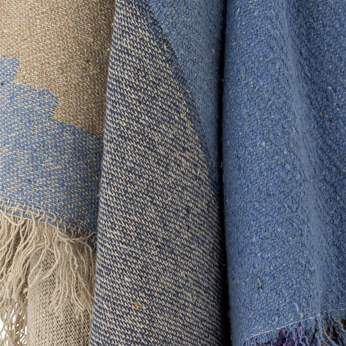 Maji Cotton Throw in Multi, close-up of woven cotton fabric showing tan, denim blue and navy colour-block panels with a tweedy flecked texture and raw fringe edge.