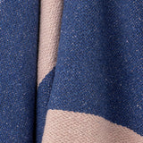Close-up of the Cadeo cotton throw in blue, showing a woven diagonal band in a paler tone against the textured, flecked fabric.