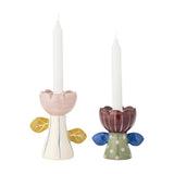 Set of 2 handpainted ceramic flower candle holders with scalloped petal cups, flared leaf-detail stems in cream/yellow and green/blue, holding white taper candles.