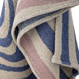 Arlie Throw in blue, a woven fabric throw with swirling bands and straight stripes, shown draped in close-up detail showing the textured weave.