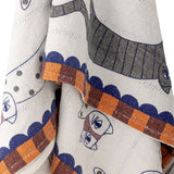 Missy Striped Throw in multicoloured cotton blend, close-up of striped cat motif with fine-line eyes, scalloped edge and checked block border in blue, orange and brown.