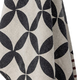 Close-up of the Forma Striped Throw in beige, showing a woven interlocking oval pattern in charcoal with a striped maroon band along one edge.