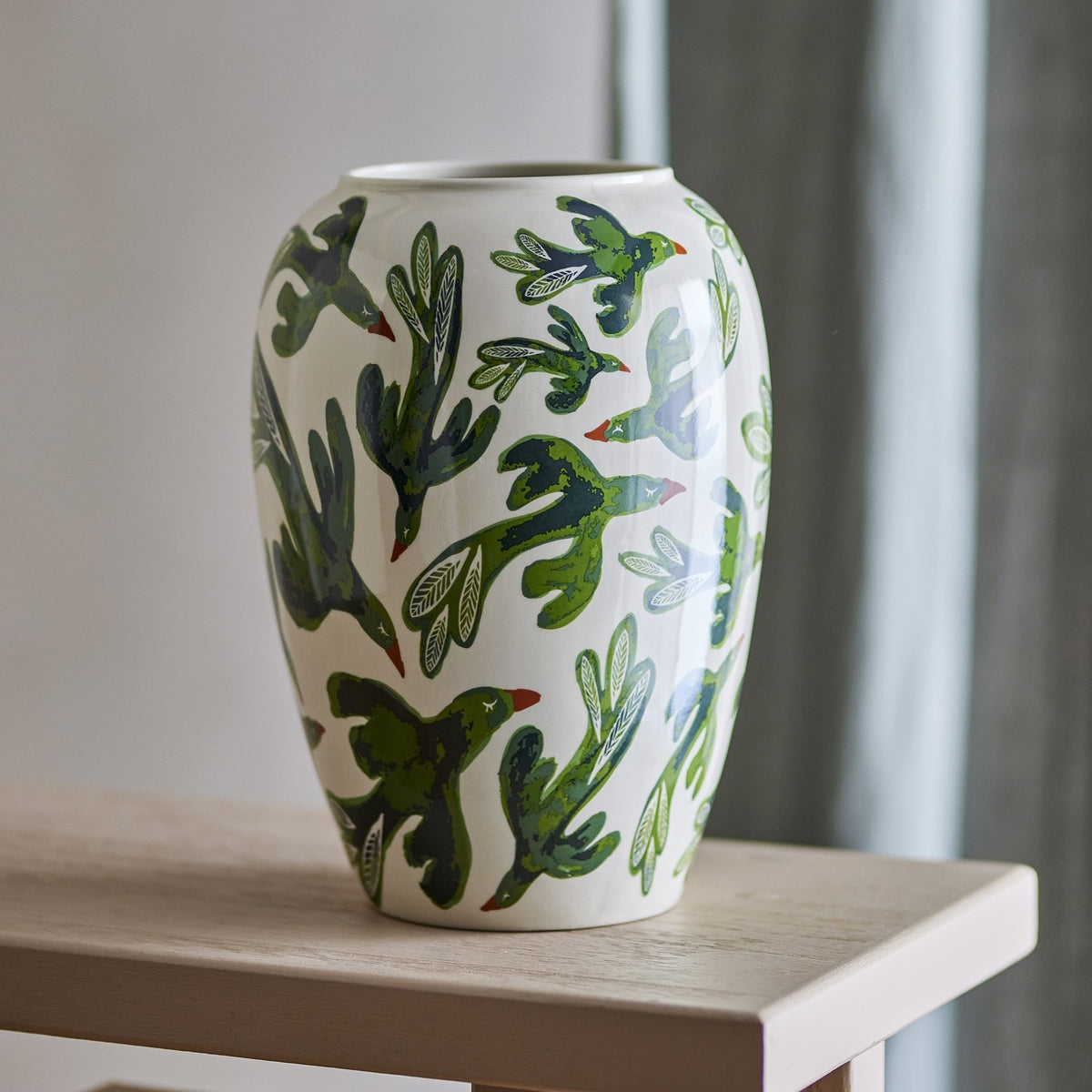 Birdliva Stoneware Vase 33cm in multicoloured green tones with an all-over bird and leaf motif, rounded shoulders and narrow rim, shown on a wooden table against a neutral background.