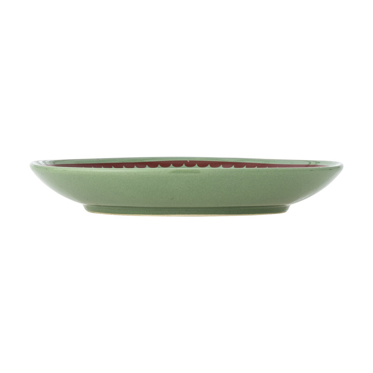 Side view of a Peo stoneware Christmas plate in green, showing its shallow round shape and footed base, set on a plain white background.