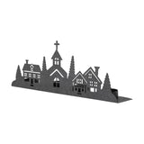 Cielo Iron Christmas Tealight Holder in black, a long strip silhouette of a village with houses, fir trees and a church with a cross, tealight cups along the base, on a white background.
