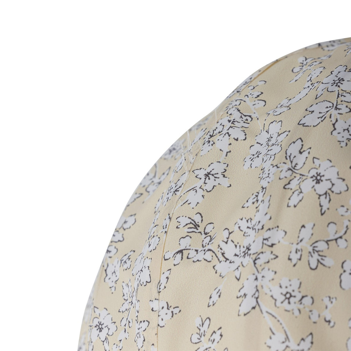 Close-up of the Pomp Floral Baby Mobile in yellow, showing ribbed fabric panels with a dense white and grey floral pattern on a hot air balloon shape, on a plain white background.