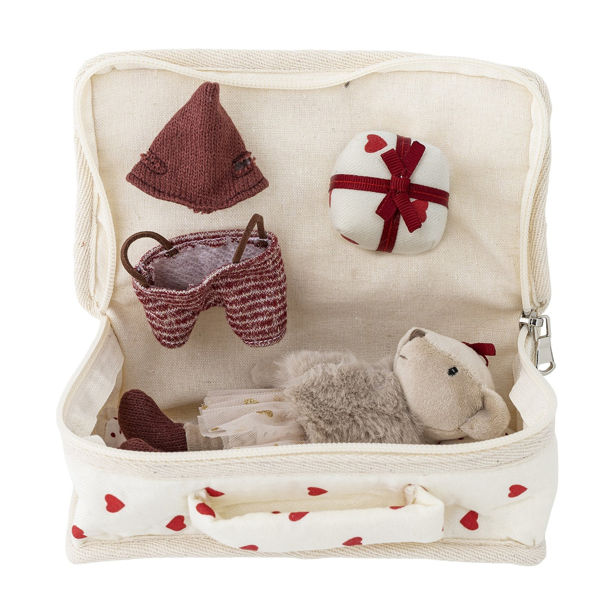 Lara Cotton Rag Doll in an open cream heart-print fabric suitcase, wearing a knitted brown bonnet and striped shorts, with a wrapped gift, fluffy ears and bow visible, on a white background.